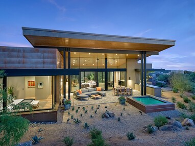 This desert home embraces the landscape with large glass panels that let views into the home and create an indoor-outdoor connection.