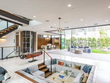 A 90-degree multi-slide door connects the indoor conversation pit to an outdoor seating area.