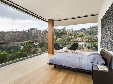 The multi-slide door in this bedroom disappears to connect the room to nature.