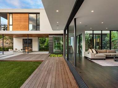 A view of the façade of the home with its floor-to-ceiling multi-slide doors completely open.