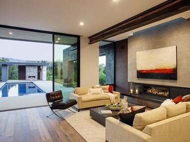 The open multi-slide visually connects the pool and the backyard to the living room.