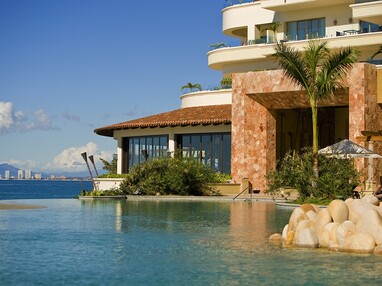 An outside view of the resort next to the ocean with large multi-slide glass doors.