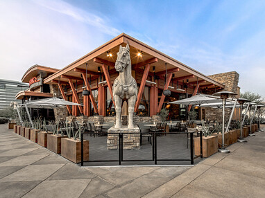 The front view of a P.F. Chang’s with a giant horse statue.