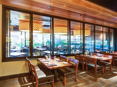 A view of multi-slide windows connecting two separate dining spaces.