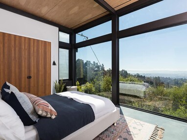 A wall of windows in the second-floor bedroom let in additional light and views of the outside greenery.