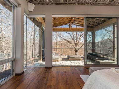 A huge sliding glass door opens from the master bedroom to an enclosed outdoor living space.