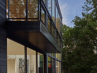 Balconies on each level of the home connect the indoors to the outdoors through wall length glazing and glass doors.