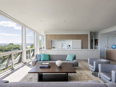 Large fixed and operable windows bring natural light into the living room and kitchen.