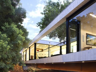 Bridge House employs floor-to-ceiling windows in the areas nearest the point where the home crosses over the creek.