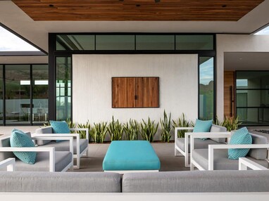 The entry courtyard of the home features a sitting area below a ribbon of windows surrounded by floor-to-ceiling glass.