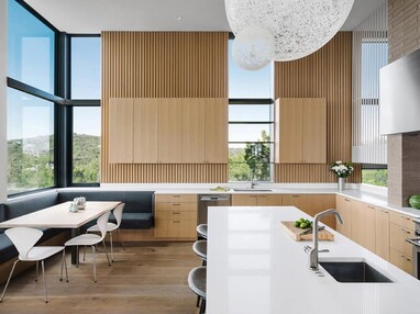 Custom windows between cabinets pour light into the kitchen.