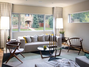 Huge fixed and operable windows behind the couch bathe the living room in natural light.
