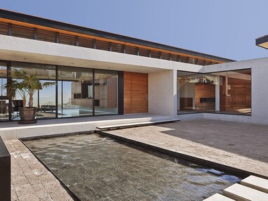 Impressive multi-slide doors that cover an entire wall and a giant fixed window in the corner frame lovely views of the pool area.