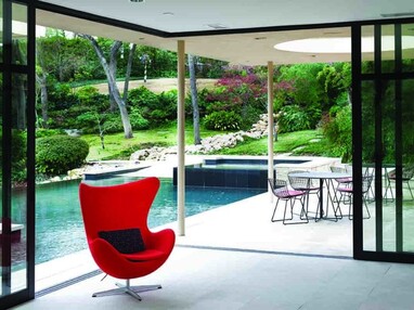 A 90-degree multi-slide door completely opens the interior of the home to the outdoor back patio and pool.