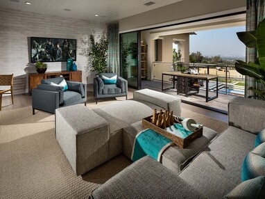 A nautical themed indoor living area is illuminated with natural light from an open multi-slide glass door that leads to the outdoors.