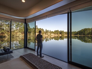 A man stares in a doorway opening directly over the lake.