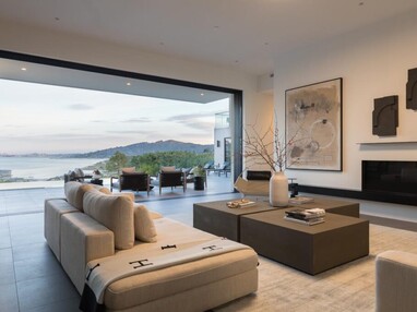 Living room with multi-slide doors tucked away revealing the San Francisco Bay view.