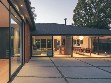 This view of the main living area from inside the master bedroom shows how two 90-degree multi-slide doors seamlessly blend the indoors with the outside.