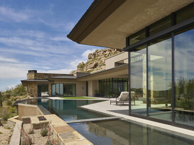 Exterior view of the backyard and sliding glass doors of a custom home.