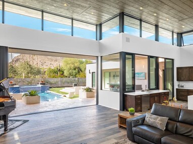 A large, open multi-slide door that opens to a backyard with a pool.