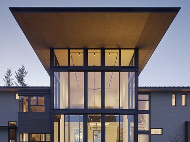 The floor-to-ceiling window wall illuminates the backyard at night when the dining room lights are on.
