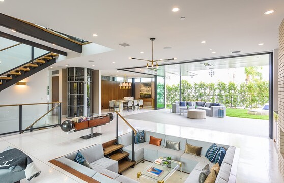 A 90-degree multi-slide door connects the indoor conversation pit to an outdoor seating area.