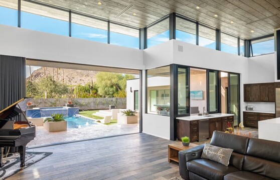 A large, open multi-slide door that opens to a backyard with a pool.