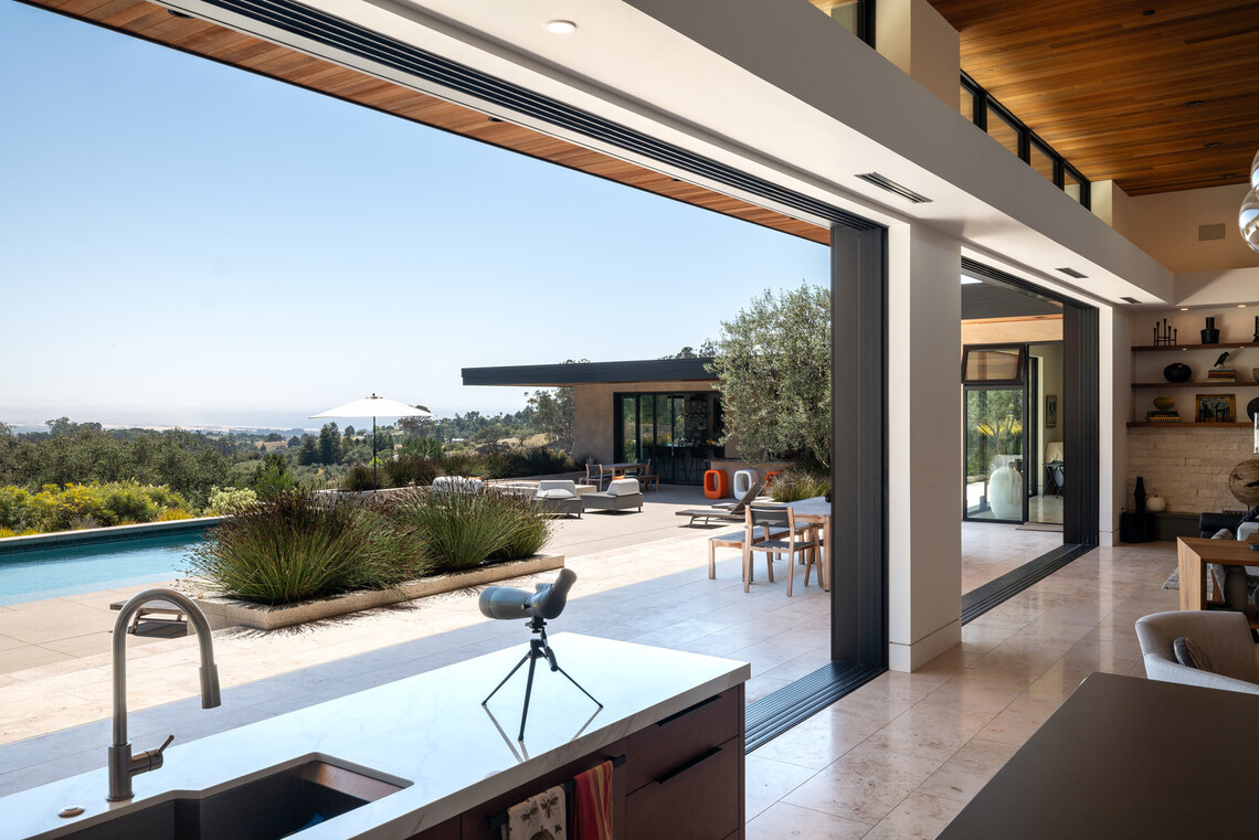 Two 25-foot-wide by 10-foot-tall moving glass walls open an Arroyo Grande home to a pool, terrace, and coastal views.