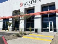 Rebranded Western Architectural Openings building exterior with signage, red awning, and concrete walkway leading to the office entrance.