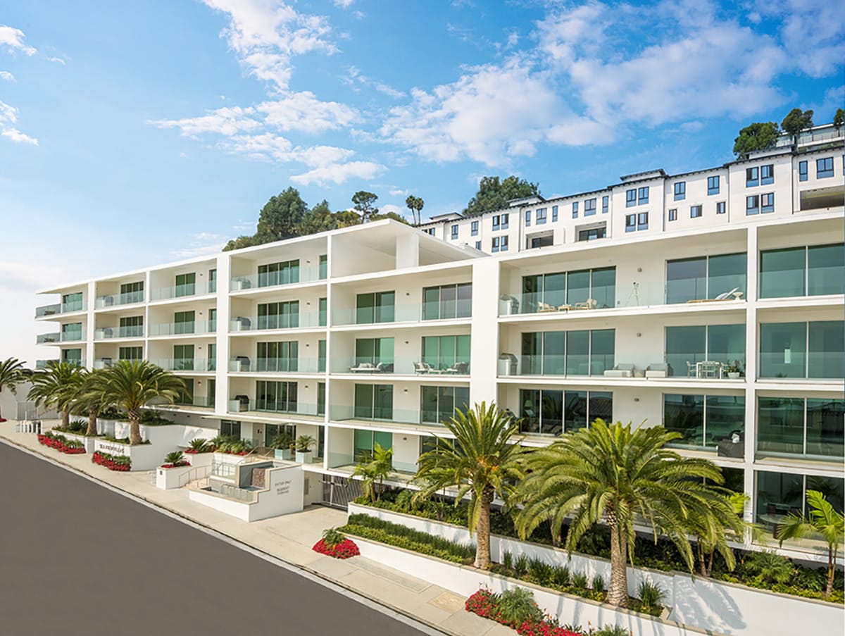 A five-story condo-complex with sliding glass leading to the balcony for every condo.