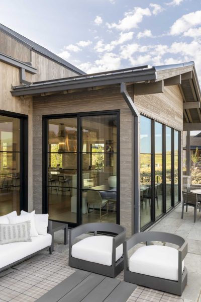 01-Simulated-Steel-UT-Bowman Large, divided light windows and multi-slide doors connect the patio to the great room.