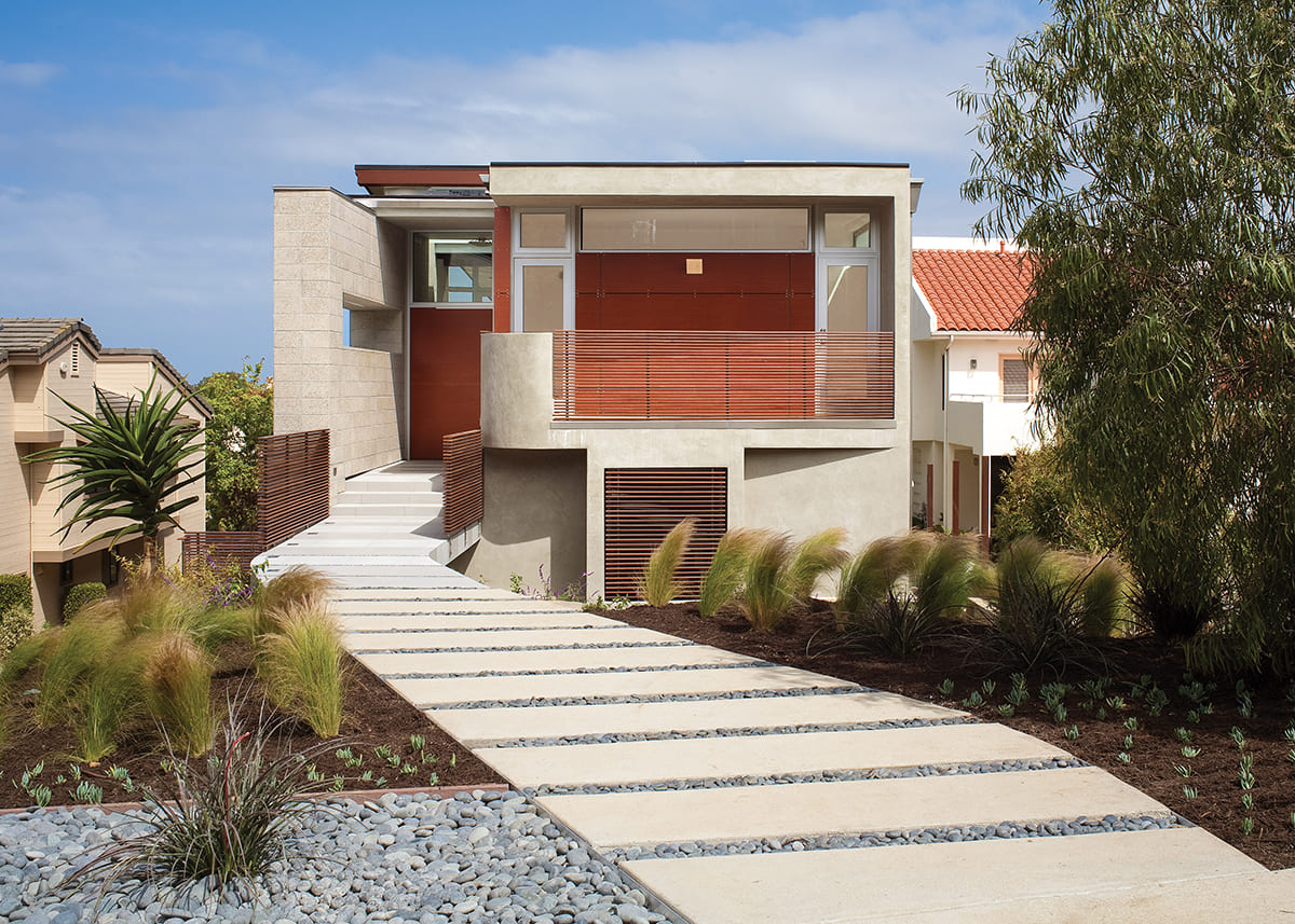 A front view of the two-story home with wooden doors and panes of glass surrounding the front and garage door.