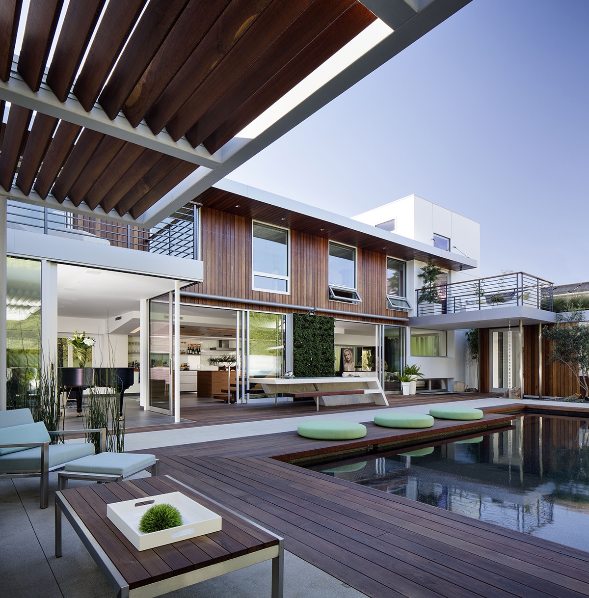 A view of the home’s glass-embracing façade with numerous sliding glass doors and windows.