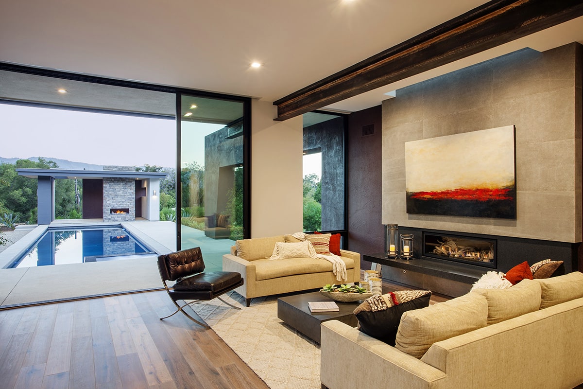 The open multi-slide visually connects the pool and the backyard to the living room.