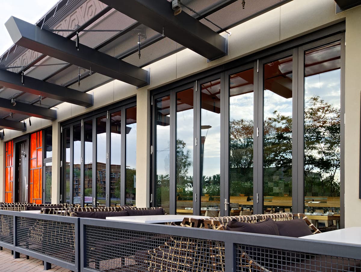 Floor-to-ceiling bi-fold doors connect the interior of the restaurant to the outside dinging tables.