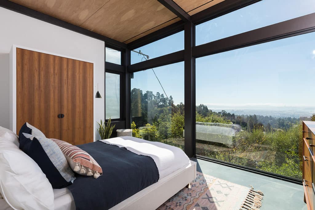 A wall of windows in the second-floor bedroom let in additional light and views of the outside greenery.