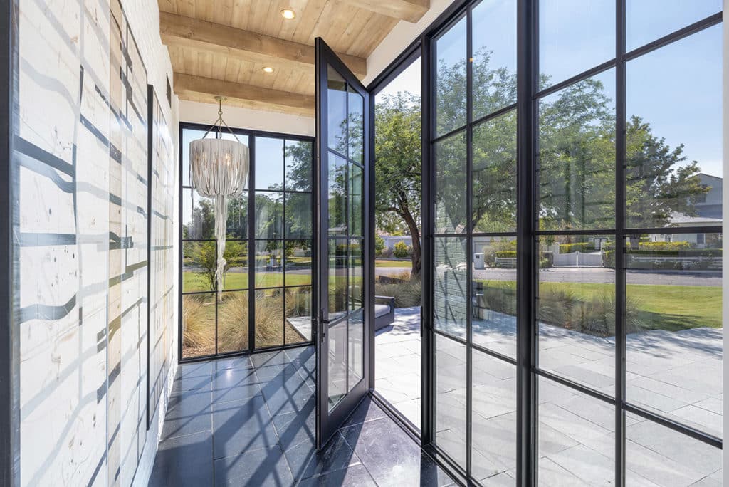 A Series 900 Hinged Door set in a glassy jewel-box entrance makes for a dramatic welcome.