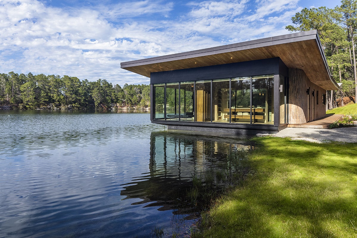A small glass home sits on a foundation that’s in the quarry.