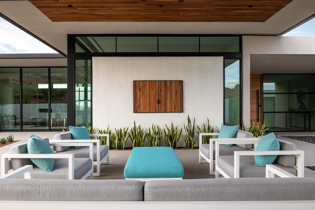 The entry courtyard of the home features a sitting area below a ribbon of windows surrounded by floor-to-ceiling glass.