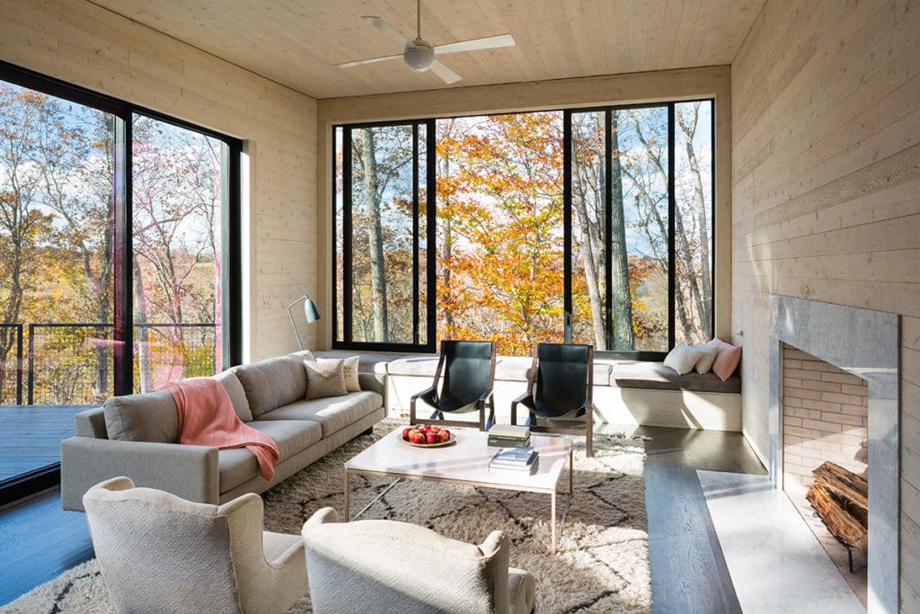 Huge moving walls of glass frame beautiful views of the Virginia countryside in this cozy living room.