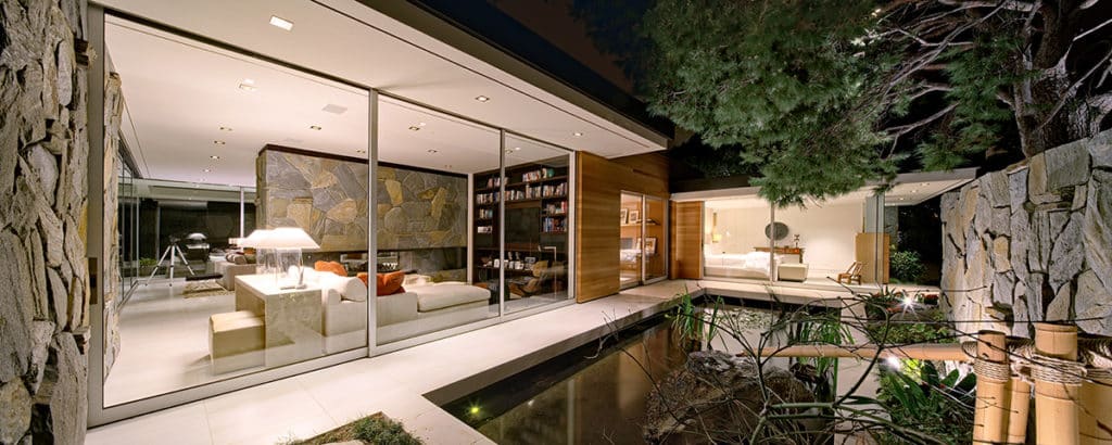 An incredible three-panel multi-slide door in the living room provides a seamless transition to the pond outside when open.
