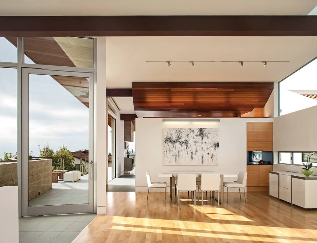 A giant Series 980 Pivot Door leading to a balcony complements the sleek, minimalist styling of the home.