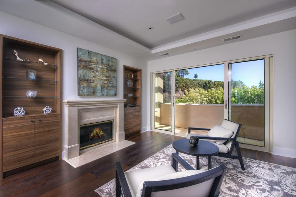 A stunning view from the porch connected to the interior lounge area with a fireplace through bi-parting, sliding glass doors.