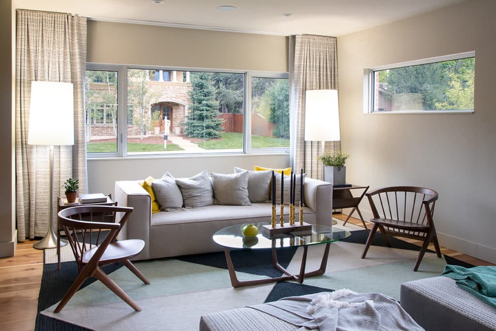 Huge fixed and operable windows behind the couch bathe the living room in natural light.