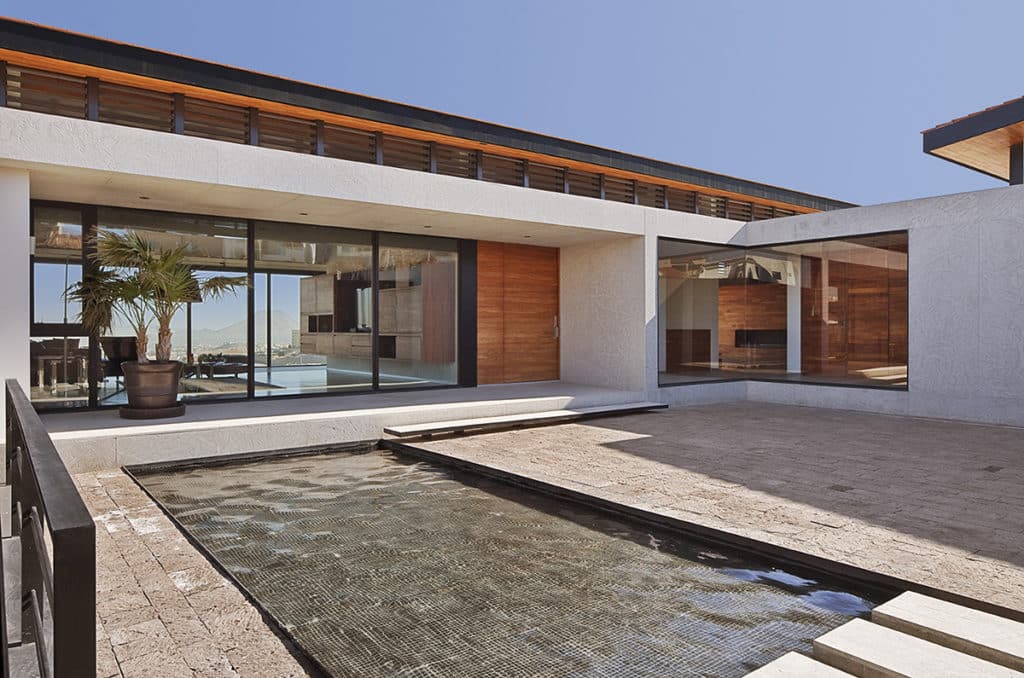 Impressive multi-slide doors that cover an entire wall and a giant fixed window in the corner frame lovely views of the pool area.