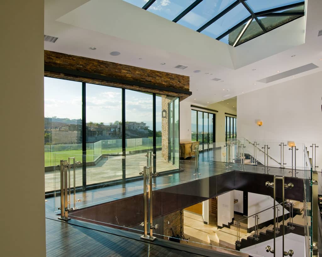 A bank of Western Window Systems multi-slide doors connected to a balcony lights the home’s hallways and staircase.