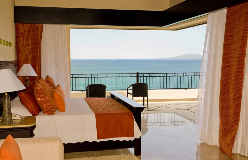A 90-degree configuration of Series 600 Multi-Slide Doors requires no connecting post, thus providing unobstructed ocean views from this bedroom with a balcony.