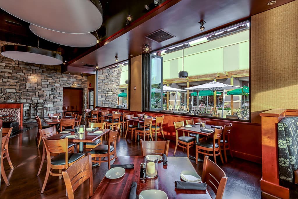 A bi-fold window wall opens up the main dining room to an outdoor dining space.