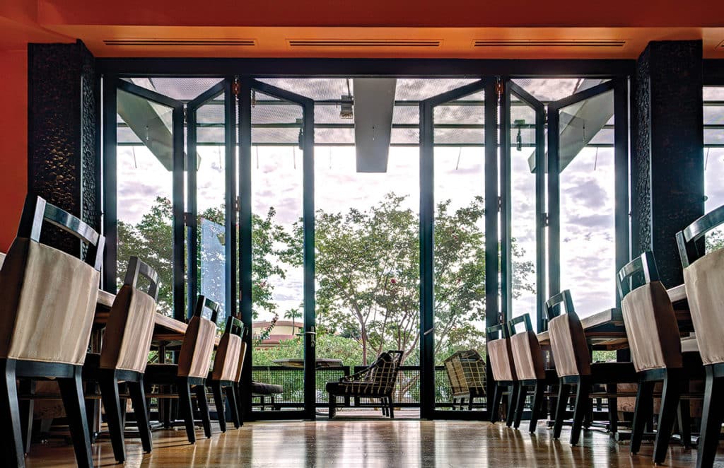 A view of bi-parting, bi-fold doors partially opening the dining room to the patio.
