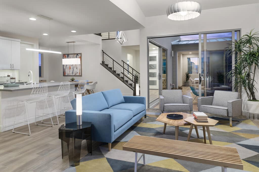 A contemporary-styled living space is connected to the outdoors with a tall multi-slide glass door.